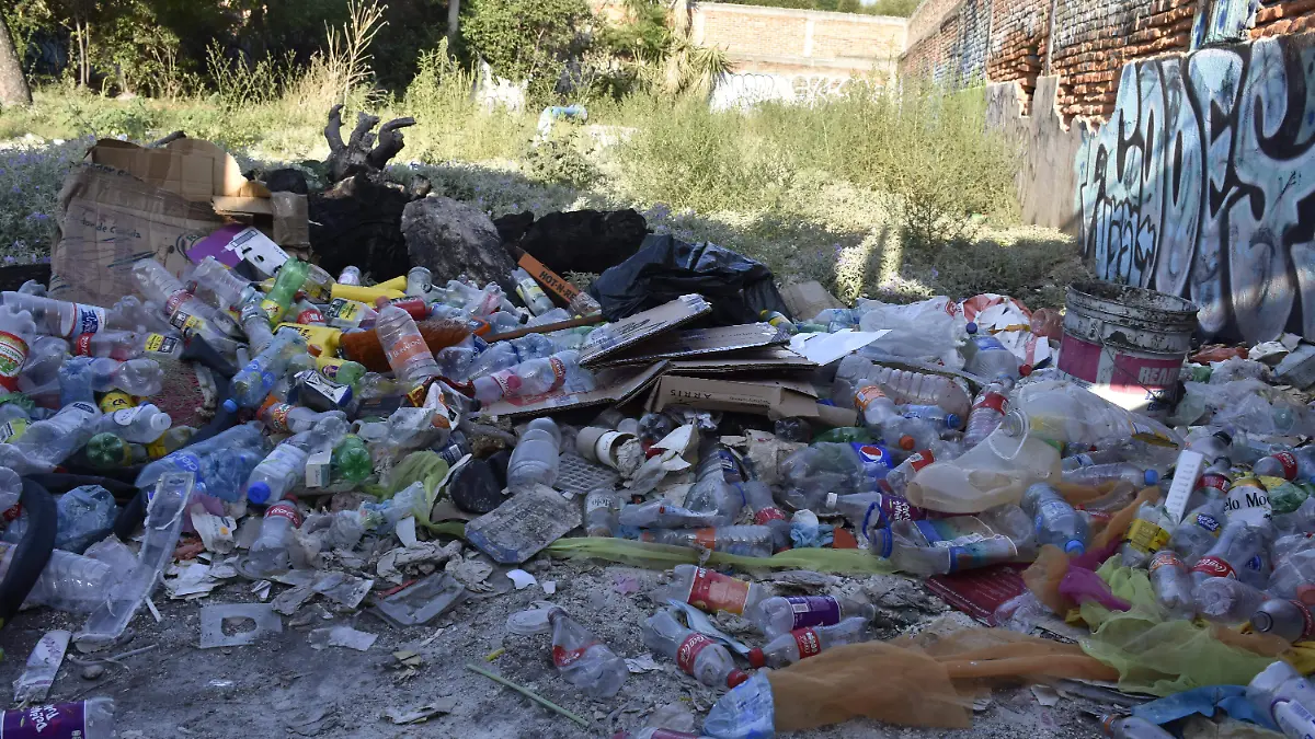 basura en un lote baldio  tapado, en Uresti 